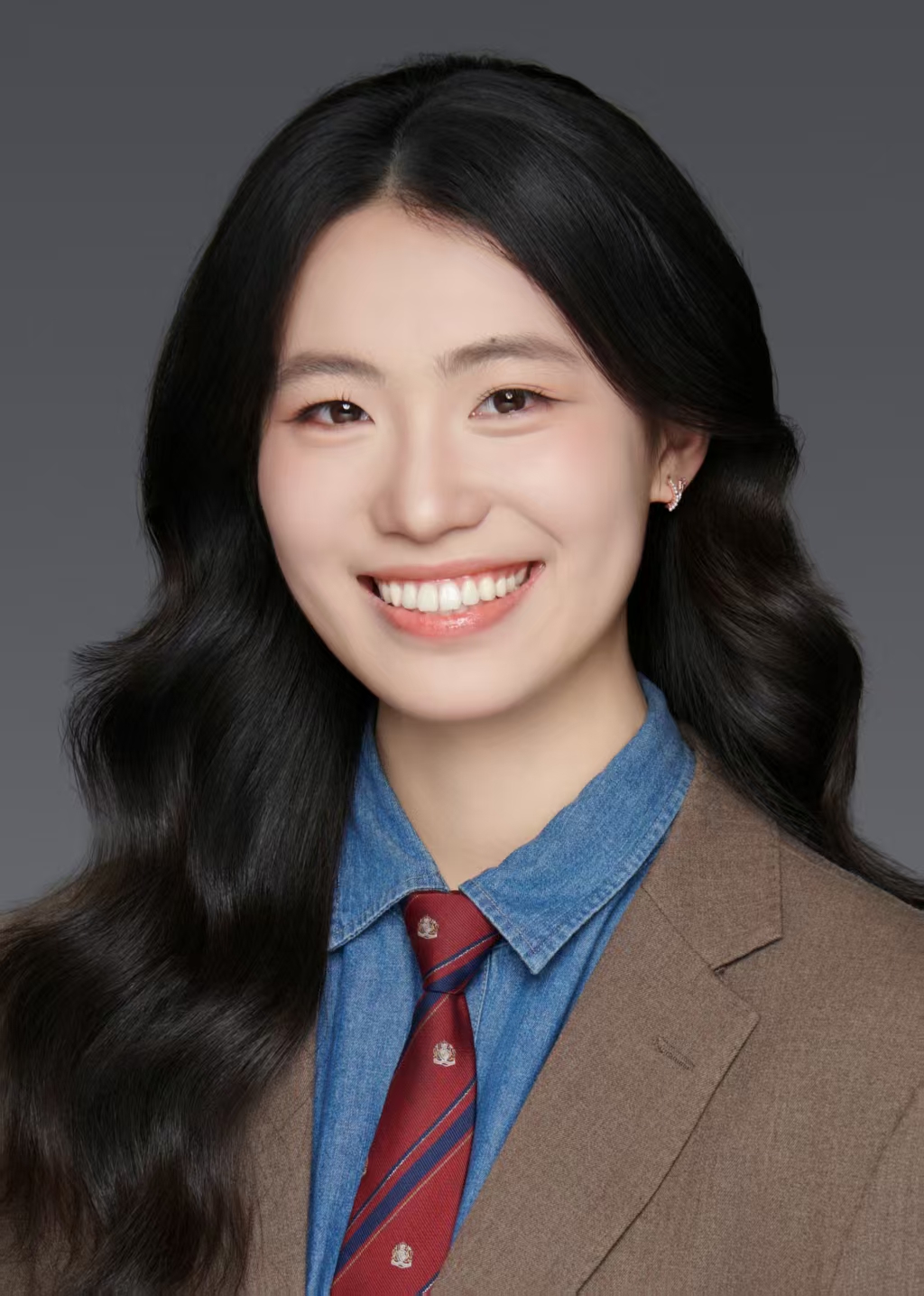 Yanting Wang smiling, wearing a brown blazer and blue shirt